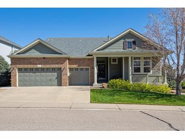 Beautiful home with a brick facade, well-maintained lawn, and an attached three car garage at 8312 Hackamore Rd, Littleton, CO 80125
