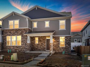 Charming two-story home featuring stone accents, gray siding, and a welcoming front porch at 779 N Tempe St, Aurora, CO 80018