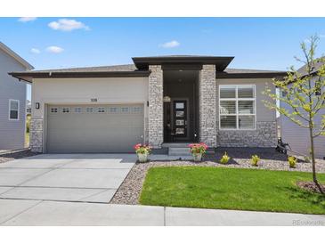 Charming single-story home featuring a well-maintained lawn, brick accents, and an attached two-car garage at 328 Simmental Loop, Castle Rock, CO 80104