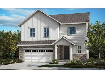 Charming two-story home with a white siding exterior, stone accents, and an attached two-car garage at 5738 N Jebel Way, Aurora, CO 80019