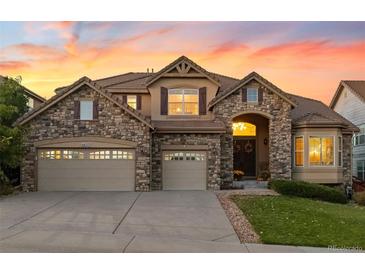 Two-story house with stone accents and a three-car garage at 6623 Esmeralda Dr, Castle Rock, CO 80108