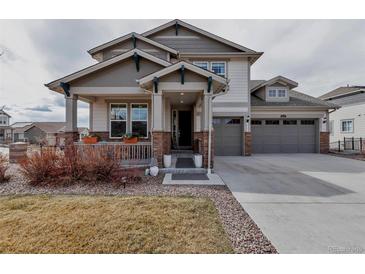Charming two-story home featuring a covered front porch and a three-car garage at 8255 S Vandriver Way, Aurora, CO 80016