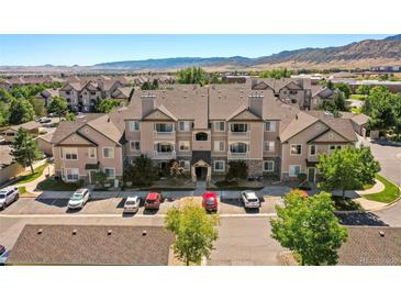 Apartment homes with manicured lawns and mature trees showcasing a well maintained community and mountain views at 9622 W Coco Cir # 203, Littleton, CO 80128