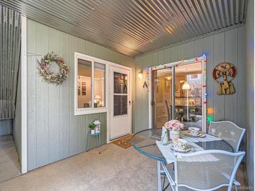 Inviting covered patio with corrugated metal ceiling and a quaint table setting, perfect for outdoor relaxation at 1057 Delta Dr # A, Lafayette, CO 80026