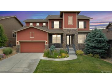 Inviting two-story home with a blend of stone and siding, complemented by a lush front yard at 21962 E Idyllwilde Dr, Parker, CO 80138