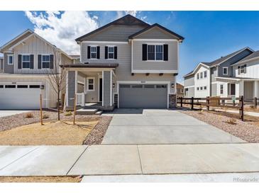 Charming two-story home with gray siding, a concrete driveway, and a well-maintained front yard at 9253 Truckee Ct, Commerce City, CO 80022