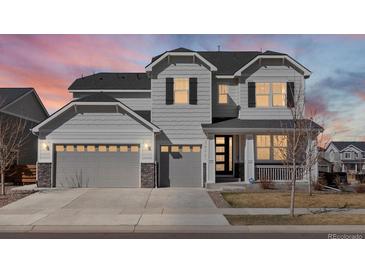 Charming two-story home featuring a three-car garage, modern door, and inviting front porch, perfect for suburban living at 904 Sundown Way, Erie, CO 80516