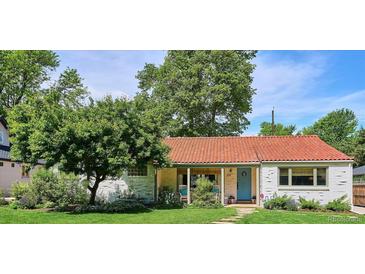 Charming home featuring a red tile roof, blue door, white brick, and a lush green lawn at 225 N Ivanhoe St, Denver, CO 80220