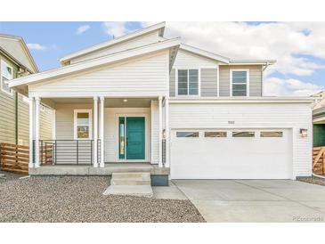 Traditional two-story home featuring a spacious two-car garage and inviting covered porch at 9303 Biscay St, Commerce City, CO 80022