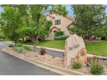 Charming home exterior with lush greenery and a stone sign that reads 