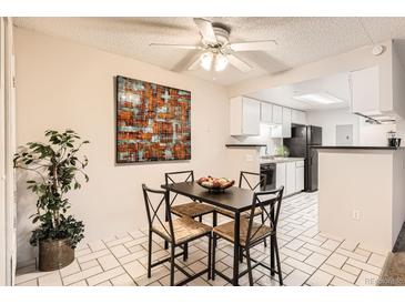 Cozy dining room with a ceiling fan and an adjacent kitchen area with black appliances at 18091 E Kentucky Ave # 202, Aurora, CO 80017
