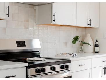 Close up of a kitchen with new stainless steel oven and backsplash at 930 S Lowell Blvd, Denver, CO 80219