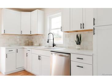 Bright kitchen featuring stainless steel appliances, white cabinets, and modern fixtures at 930 S Lowell Blvd, Denver, CO 80219