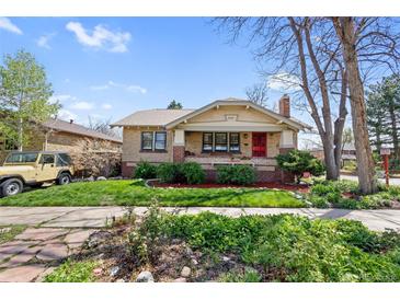 Charming brick home with a well-maintained lawn, a red door, and lush landscaping at 3242 Utica St, Denver, CO 80212