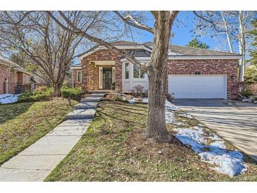 Brick home with attached garage and landscaped yard at 111 Blue Heron Cir, Greenwood Village, CO 80121