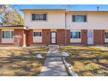 Brick front exterior of a charming townhome with a well-maintained lawn at 1170 S Troy St, Aurora, CO 80012