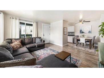 Open concept living room featuring a cozy sectional sofa and a dining area with modern decor at 7937 Chase Cir # 176, Arvada, CO 80003