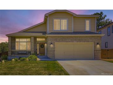 Charming two-story home with a well-manicured lawn and a welcoming front porch and two-car garage at 5130 Morning Glory Pl, Highlands Ranch, CO 80130