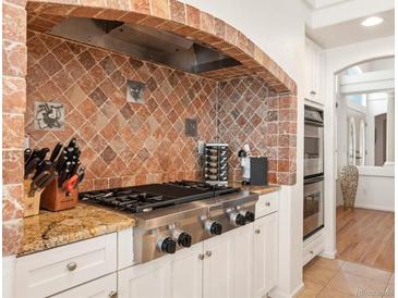 Gourmet kitchen features stainless steel appliances, decorative tile backsplash and granite countertops at 6328 S Ouray Way, Aurora, CO 80016