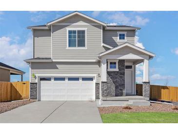 Charming two-story home with a two-car garage and stone accent, offering a blend of modern design and classic appeal at 17945 E 94Th Ave, Commerce City, CO 80022