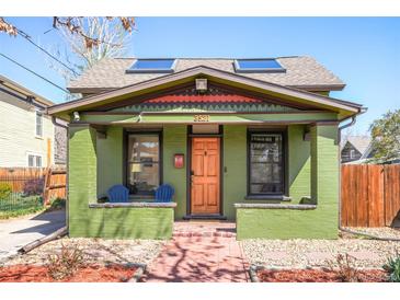 Charming home featuring a vibrant green facade, skylights, and a cozy front porch with colorful Adirondack chairs at 3521 W 40Th Ave, Denver, CO 80211