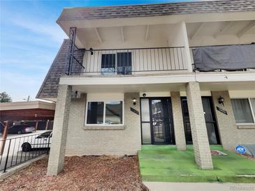 Townhouse exterior with a private balcony, covered parking, and well-maintained landscaping at 11422 W 17Th Pl, Lakewood, CO 80215