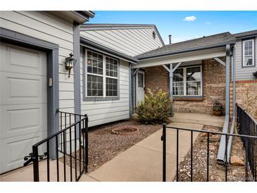 Charming home exterior with gray siding, brick accents, walkway, and inviting covered front porch at 14192 E Baltic Pl, Aurora, CO 80014