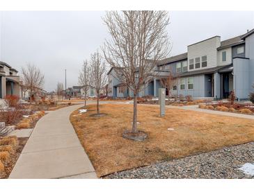 A street view of homes with sidewalks and maintained lawns on a cold winter day at 16102 E 47Th Pl, Denver, CO 80239