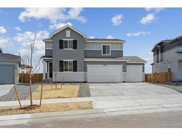 Beautiful two-story home with a three car garage and manicured front yard at 9992 Racine St, Commerce City, CO 80022
