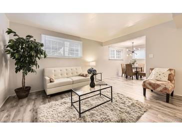 Bright living room features modern decor, neutral tones, and an open layout to the dining area at 6800 E Tennessee Ave # 111, Denver, CO 80224