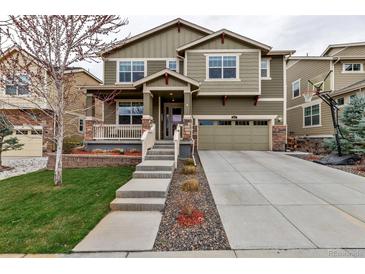 Inviting two-story home featuring a well-manicured lawn, concrete driveway, and a welcoming front porch at 697 Sundance Cir, Erie, CO 80516