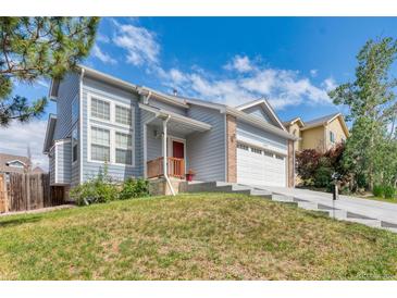 Charming two-story home with blue siding, well-manicured front yard, and two-car garage at 12388 Jasmine St, Brighton, CO 80602