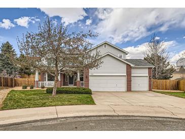 Traditional two-story home featuring a three-car garage, red brick accents, and a well-maintained front lawn at 17979 E Dorado Dr, Centennial, CO 80015