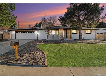 Charming ranch-style home boasts a well-maintained lawn, attractive landscaping, and a two-car garage at 8236 W 71St Pl, Arvada, CO 80004