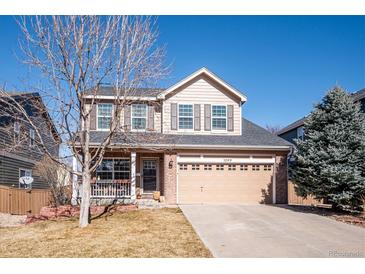 Charming two-story home featuring a well-manicured lawn, a two-car garage, and a welcoming front porch at 1099 Thornbury Pl, Highlands Ranch, CO 80129