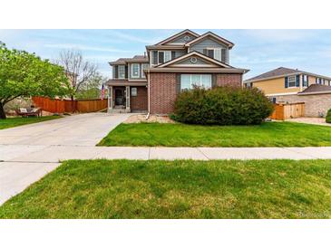 Charming two-story home with a well-manicured lawn, mature trees, and brick and siding exterior at 4873 S Fultondale Way, Aurora, CO 80016