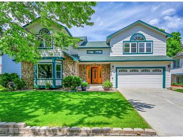 Charming two-story home featuring stone accents, well-manicured lawn and lush landscaping at 379 Lincoln Ct, Louisville, CO 80027