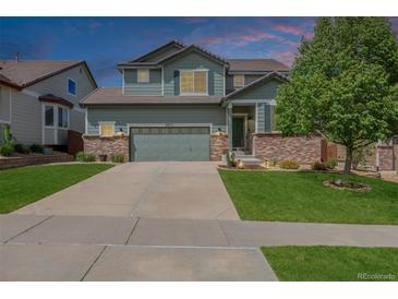 Charming two-story home with a lush lawn, two-car garage and meticulous landscaping at 16671 E Prairie Goat Ave, Parker, CO 80134