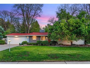 Charming single story home boasts a well-manicured lawn and mature trees at 7900 Crest Dr, Lakewood, CO 80214