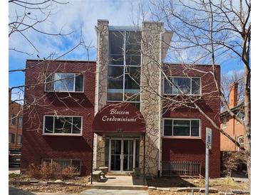 Brick condominium building featuring a covered entrance, stone accents, and lots of natural light at 1131 N Lafayette St # 304, Denver, CO 80218
