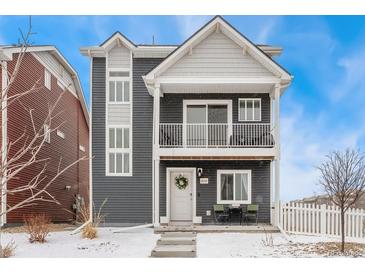 Charming two-story home featuring a covered balcony, gray siding, and a welcoming front door with a wreath at 18552 E 54Th Ave, Denver, CO 80249