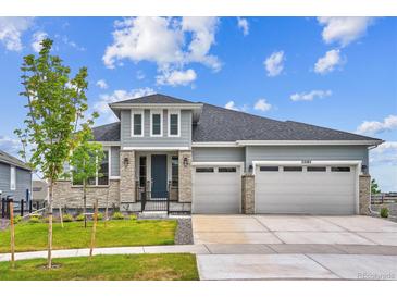Beautiful single-Gathering home featuring a manicured lawn, stone accents, and a two-car garage at 22183 E Rocky Top Pl, Aurora, CO 80016