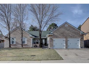 Charming brick home featuring an attached two car garage and a well-manicured lawn at 7006 S Miller Ct, Littleton, CO 80127