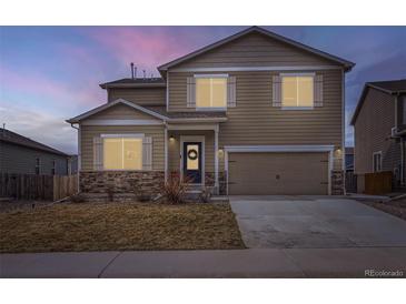 Charming two-story home with stone accents, a two-car garage, and a welcoming front door with a wreath at 14799 Longhorn Dr, Mead, CO 80542