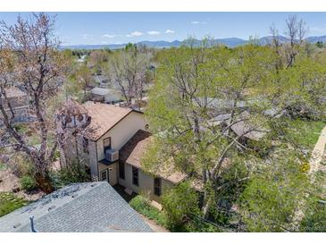 Charming two-story home features a unique tower and lush mature trees, creating a serene setting at 306 E Cannon St, Lafayette, CO 80026