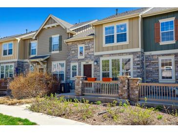 Charming townhouse featuring stone accents, a cozy front porch, and well-maintained landscaping at 835 Stony Mesa Pl, Castle Rock, CO 80108