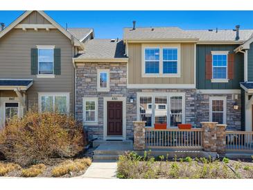 Charming townhome featuring stone accents and a cozy front porch with decorative flower pots at 835 Stony Mesa Pl, Castle Rock, CO 80108