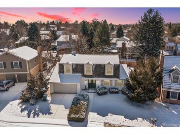 Charming two-story home with attached garage, dormer windows, mature trees, and snow-covered yard at 6330 E Irwin Pl, Centennial, CO 80112