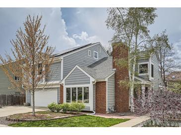 Charming two-story home featuring gray siding, brick chimney, and a well-maintained front yard at 5275 Holmes Pl, Boulder, CO 80303
