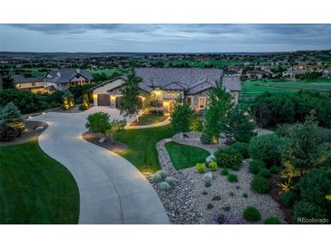 Stunning exterior view of the estate home with lush landscaping, a circular driveway, and a beautiful horizon view at 4822 Bandera Pl, Parker, CO 80134
